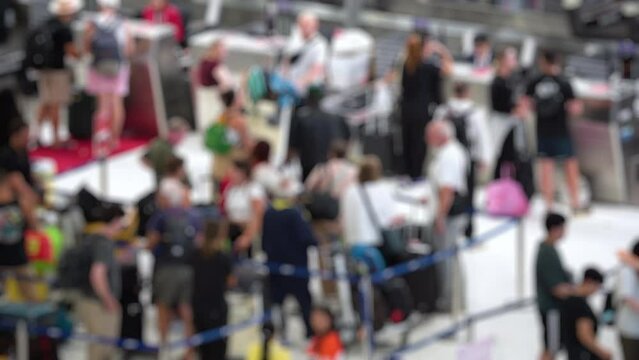 Blurred people in airport. People standing in check-in queue at airport terminal and waiting for the flight. Blurred footage. 