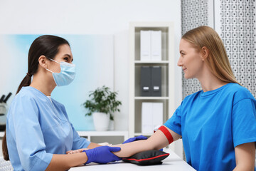 Laboratory testing. Doctor taking blood sample from patient at white table in hospital