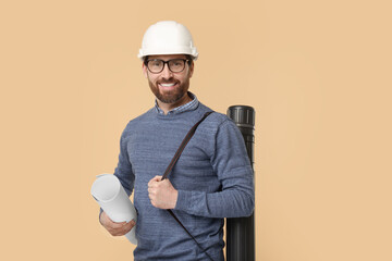 Architect in hard hat with drawing tube and draft on beige background