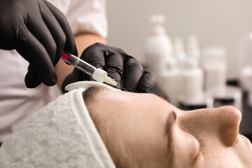 Cosmetologist giving facial injection to patient in clinic, closeup. Cosmetic surgery