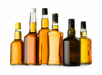 Different sorts of whiskey in glass bottles isolated on white