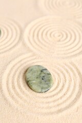 Fototapeta na wymiar Zen garden stone on beige sand with pattern