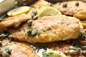 Delicious chicken piccata with herbs and lemons as background, closeup