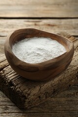 Fototapeta na wymiar Baking powder in bowl on wooden table