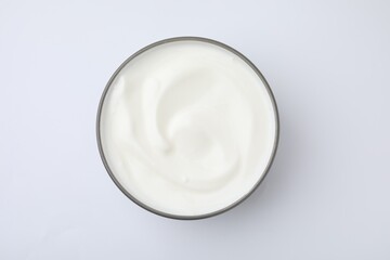 Delicious natural yogurt in bowl on white background, top view