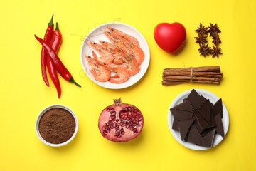 Natural aphrodisiac. Different products and heart model on yellow background, flat lay