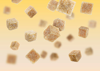 Brown cane sugar cubes falling on golden gradient background