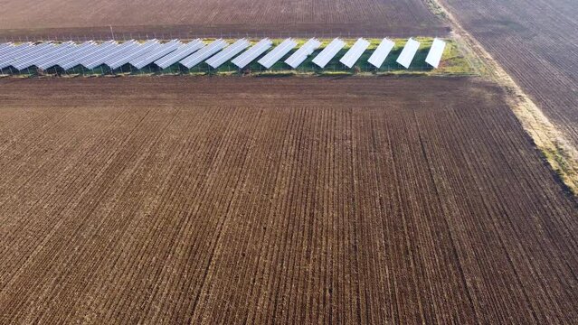 Solar panels farm in the middle of a plowed field