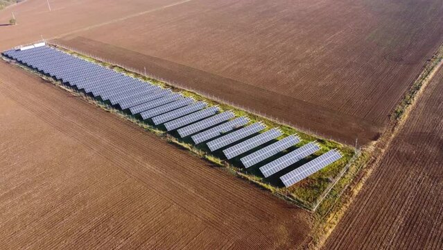 Solar panels farm in the middle of a plowed field