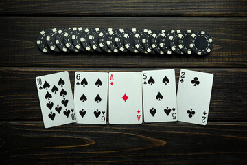 Win at the poker club. Combination of high card playing cards and chips on a vintage table. Space for advertising