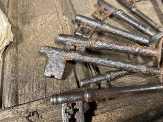 A bunch of antique  17th and 18th century keys from an old English country house laying on an old oak table. 