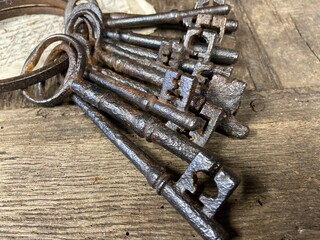 A bunch of antique  17th and 18th century keys from an old English country house laying on an old oak table. 