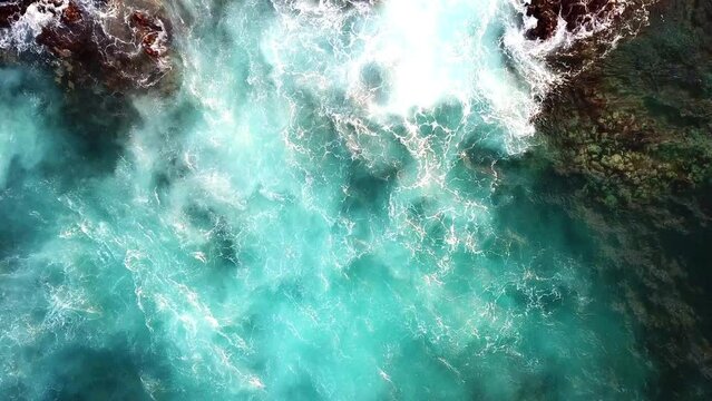 Drone view of Atlantic ocean waves meet with underwater pointed rocky. Blue rough sea with big waves with foam crashing against the rocks, south of Tenerife, Canary island