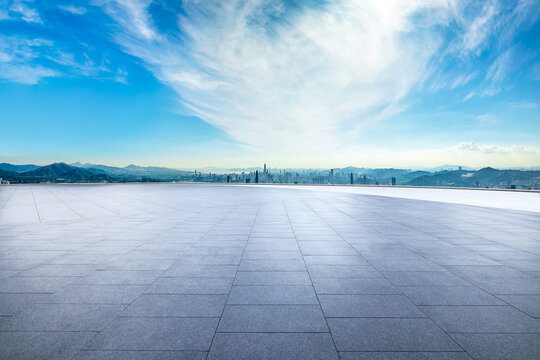 Empty square floor and modern city skyline with mountains