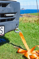 Tow hook with orange strap on car. Towing equipment.