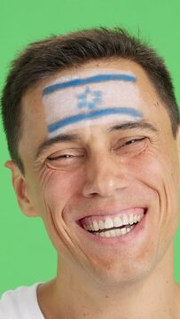 Man with a israeli flag painted on the face smiling