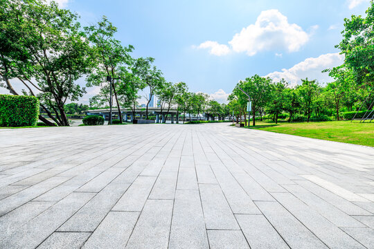 Empty square floor and trees with buildings in park