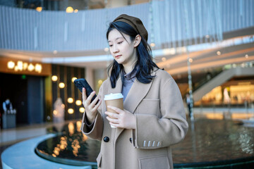 Young Woman Enjoying Coffee Break with Smartphone