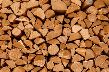 Stacked firewood background of cut wooden log for fireplace