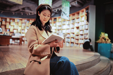 Young Woman Enjoying a Book in Cozy Bookstore Setting