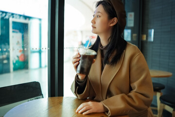 Elegant Woman Enjoying Coffee in Cozy Cafe Setting