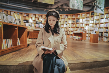 Serene Bookstore Moment: Young Woman Engrossed in Reading