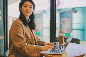 Professional Woman Working on Laptop in City Cafe