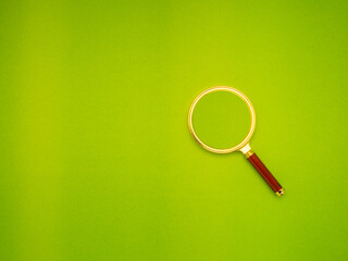 Magnifying glass on green background.