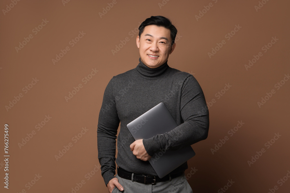 Poster Portrait of happy man with laptop on brown background