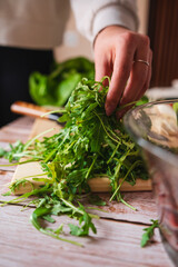 A close up of girl's or woman's hands peeling and cutting vegetables with knife making salad	