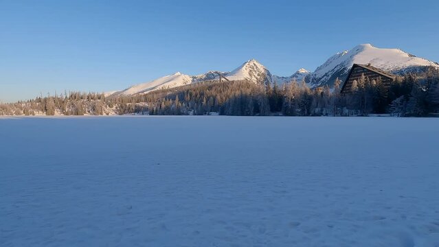 Snow covered STrbske pleso lake with peaks above in HIgh Tatras mountains in Slovakia during winter sunrise