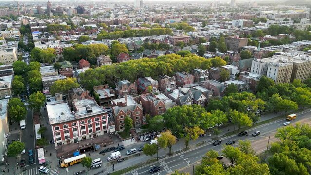 The dynamic cityscape of Bushwick, Brooklyn as the sun sets over a skyline decorated with buildings and trees. Shot from above, this drone footage offers a unique perspective on city life