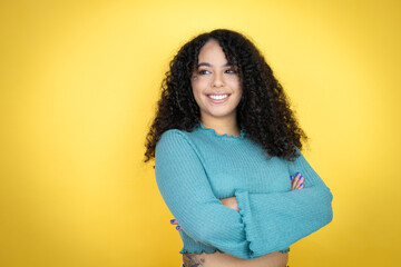 African american woman wearing casual sweater over yellow background looking to side, relax profile...