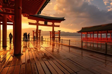 Fototapeten The red torii gate of Itsuk Japanese temple stands on the water surface at sunset © Kien