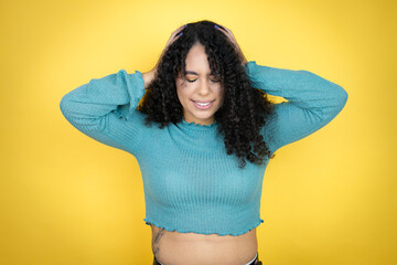 African american woman wearing casual sweater over yellow background suffering from headache...