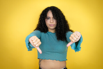 African american woman wearing casual sweater over yellow background with angry face, negative sign...
