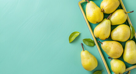 Fresh organic yellow pears in a tray on a blue background. Copy space. Top view. - obrazy, fototapety, plakaty