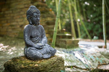 A sculpture of Buddha outdoors in nature as a religious decoration