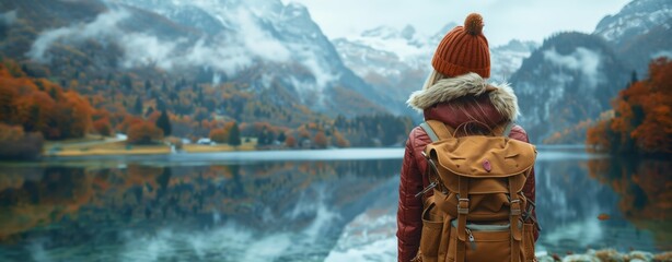 Adventurer Gazing at a Misty Autumn Mountain Landscape from a Tranquil Lake Shore