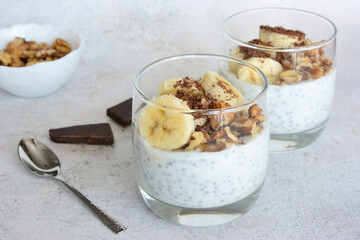 a glass of oatmeal with bananas,yogurt, walnut and chia seeds  