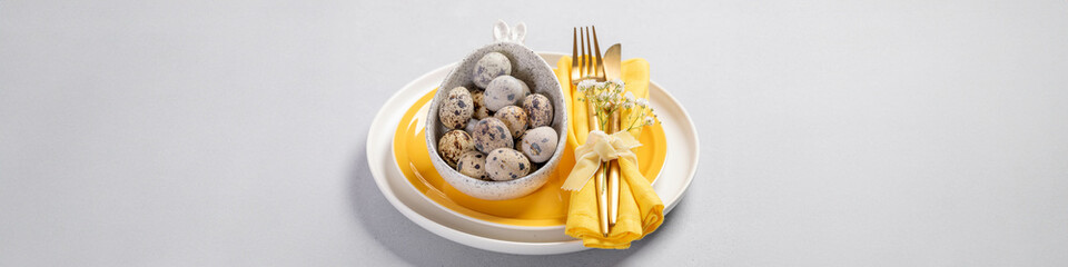 Advertising Easter wide banner with white yellow dishware, quail eggs, golden cutlery on gray.