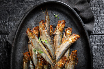 Healthy and fresh smoked sprats as appetizer by the sea.