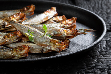 Tasty and salty smoked sprats on white food paper. - 766310274