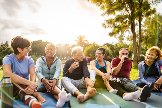 Happy multiracial senior friends drinking a tea after workout activities in a park