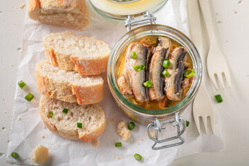 Healthy and canned smoked sprats served with chive and bread. - 766313835