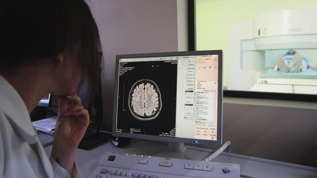 In the medical laboratory, the patient undergoes an MRI or CT scan under the supervision of a radiologist; in the control room, the doctor observes the procedure and monitors the results of the brain 