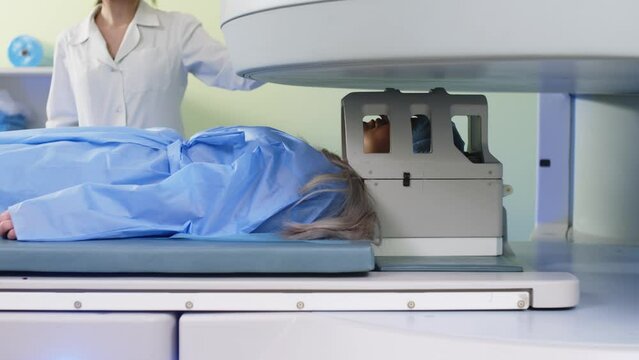 Magnetic resonance imaging in the study of the human body. A doctor performs an MRI on a patient in the clinic. The girl lies in an MRI machine. Modern technologies in medicine.