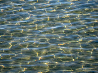 Fototapeta na wymiar Water surface in the bay of Ogliastro Marina in Italy.