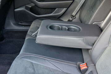 Armrest in the luxury passenger car with cup holder between the front seats