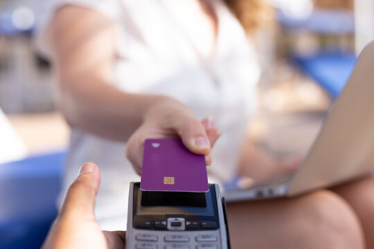 woman is paying for something with a purple credit card